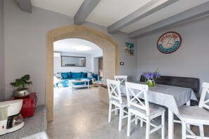 Ein Essbereich mit Tisch, Stühlen und einer Uhr an der Wand.