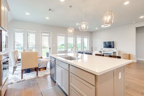 A modern kitchen with a large island, stainless steel appliances, and pendant lighting. - 10 Min from Austin! High-End Home w/ nice backyard (Manor)