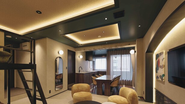 Un interior moderno con comedor, cocina y un altillo con escalera.