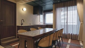 Una cocina moderna con una isla central, armarios de madera oscura y una estufa empotrada.