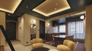 Un interior moderno con comedor, cocina y escalera.