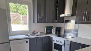 Une cuisine équipée d’un lave-vaisselle, d’un four à micro-ondes, d’une cuisinière et de placards.