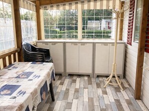 A room with a table, chairs, a radiator, and a window with a view of greenery. - Mobile home 6 persons air-conditioned- la pignade - Ronce les bains (La Tremblade)
