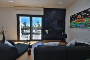 A modern living room with a sofa, a coffee table, and a painting on the wall.