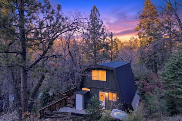 A-frame cabin tucked among the trees with a private hot tub.