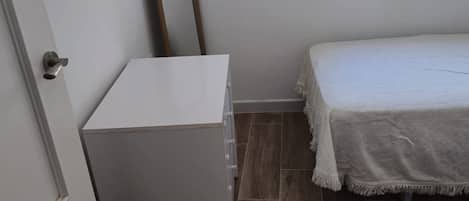 Tabla de planchar con plancha, internet y ropa de cama