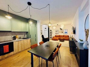 Una cocina moderna con comedor, un sofá y televisor en la sala.