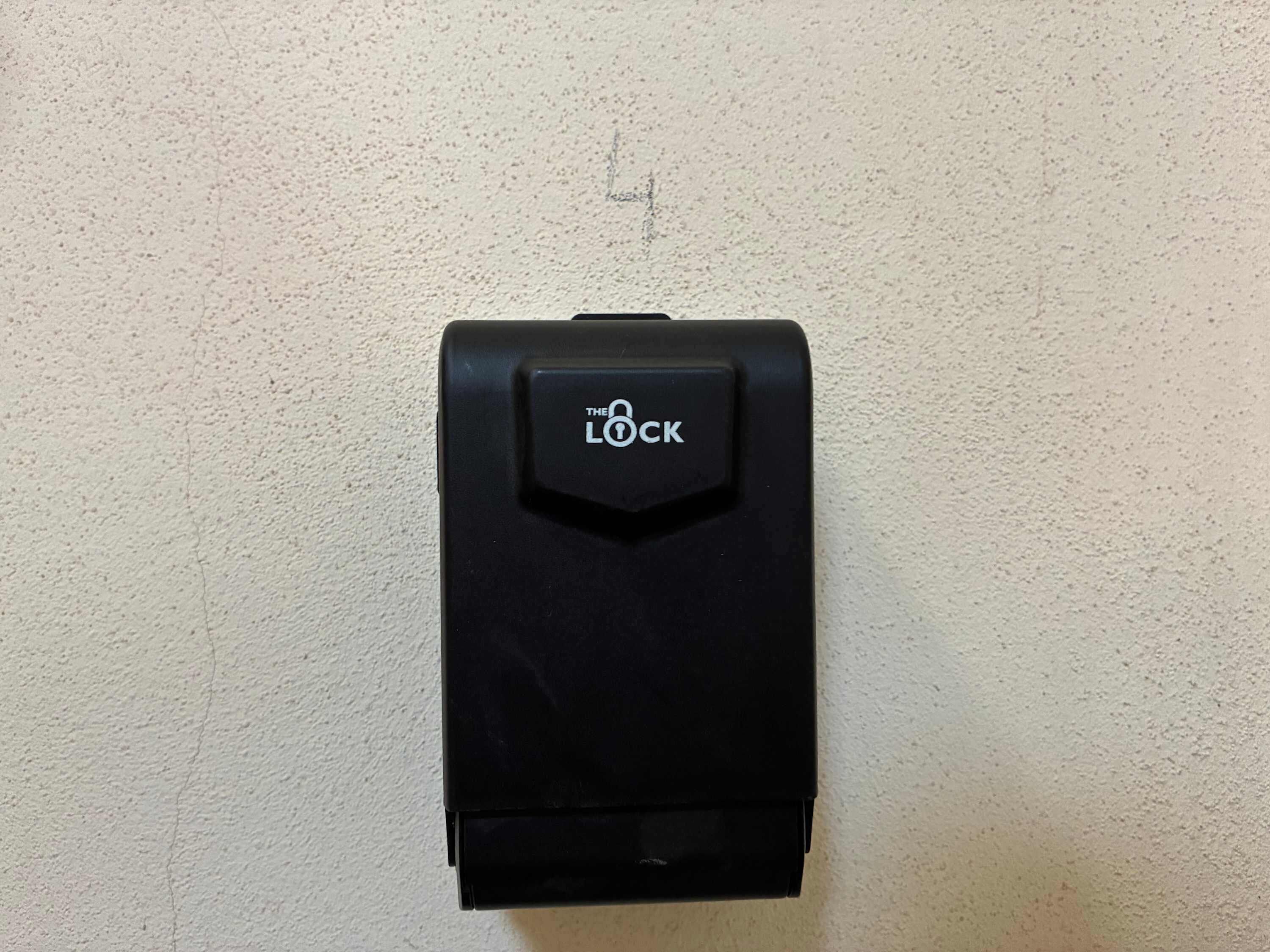 A black lock mechanism on a textured wall.
