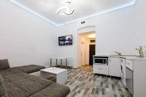 A modern apartment with a living area, a kitchen, and a TV mounted on the wall. - Joy City Stay Ultracentral Chic (Timișoara)