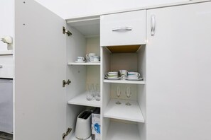 A white kitchen with open cabinets, a toaster, and a coffee maker. - Joy City Stay Ultracentral Chic (Timișoara)