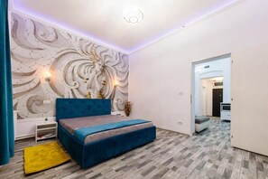 A bedroom with a blue bed, a decorative wall, and a small white nightstand. - Joy City Stay Ultracentral Chic (Timișoara)
