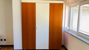 Une pièce avec une armoire en bois, une fenêtre et un plancher en bois.