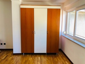 A room with a wooden wardrobe, a window, and a wooden floor. - Joy City Stay George 12 (Timișoara)