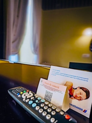 A remote control, a business card, and a QR code on a table. - Joy City Stay Executive Comfort in Central Area (Timișoara)