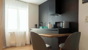 Une cuisine moderne équipée d’un four à micro-ondes, d’un évier et d’un coin repas avec deux chaises.