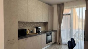 A modern kitchen with a microwave, coffee maker, and oven. - Joy City Stay Mangalia 5 (Timișoara)