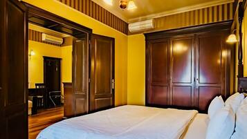 A bedroom with a wooden bed, a ceiling fan, and a door leading to a dining area.
