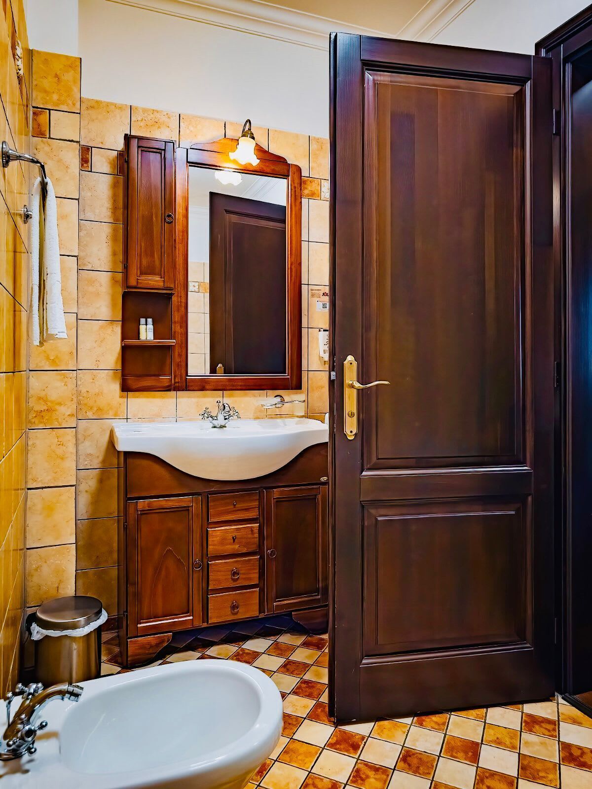 A bathroom with a wooden vanity, a sink, a mirror, a shower, and a toilet.