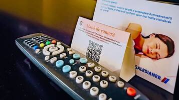 A remote control, a business card, and a QR code on a table.