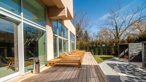 A wooden deck with lounge chairs, a trash can, and a stone pathway. - Joy City Stay - Memorandului (Timișoara)