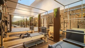 A Pilates studio with mirrored walls, exercise equipment, and wooden accents. - Joy City Stay - Memorandului (Timișoara)