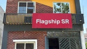 A multi-story building with a red sign reading 'Flagship SR' on the ground floor. - Hotel SR (Sanwer)