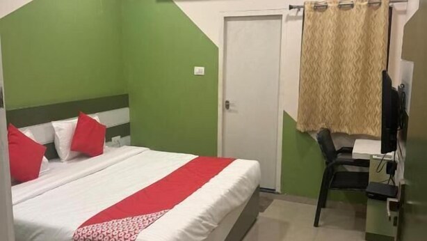 A bedroom with a bed, a desk, a chair, and a door. - Hotel SR (Sanwer)
