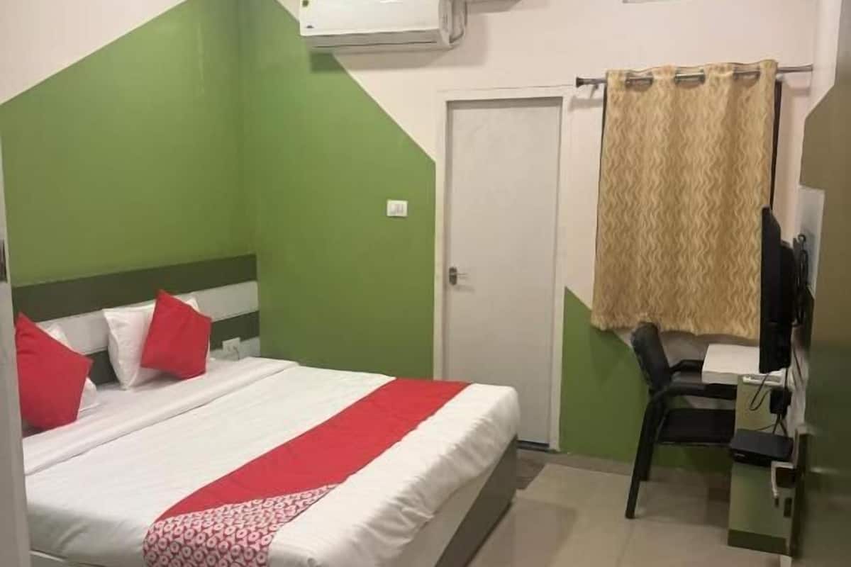 Un dormitorio con cama, escritorio, silla y puerta.