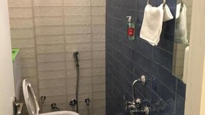 A bathroom with a toilet, a shower, and a sink. - Hotel SR (Sanwer)