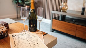 A bottle of wine, two glasses, and a welcome brochure on a table. - Cozy 1BR Seaside Apt in Brighton Marina Village (Brighton and Hove)