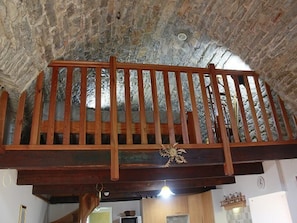 A wooden balcony with a rustic stone ceiling. - "Gîtes in la Couvertoirade "LE LARZAC (La Couvertoirade)