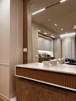 A modern bathroom with a large mirror, a wooden vanity, and a countertop with a bowl sink. - Zest Premium Apartments 4 (Durrës)