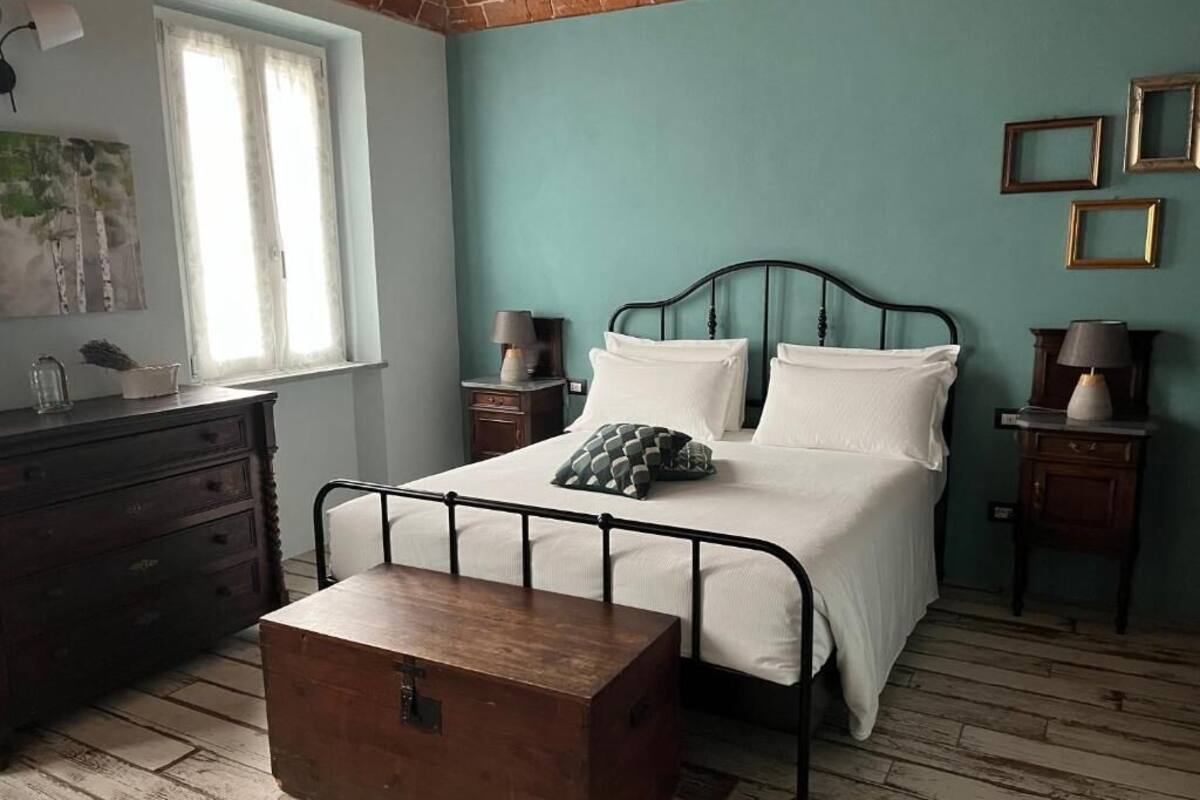 A bedroom with a bed, bedside tables, a dresser, and a chest of drawers.