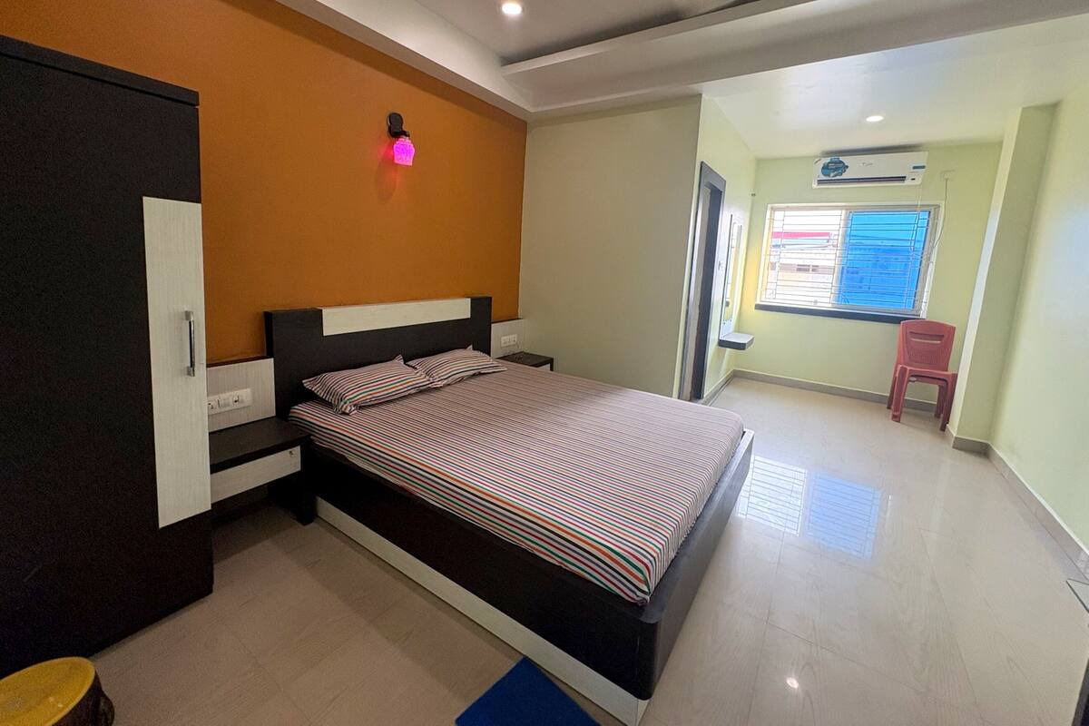 A bedroom with a bed, wardrobe, and a small window.