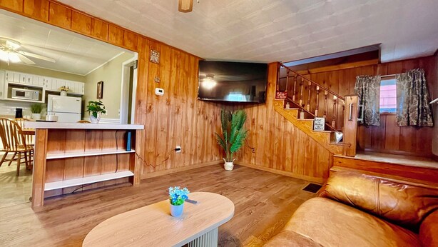 Un intérieur en bois comprenant une cuisine, un coin repas, un espace salon et un escalier.