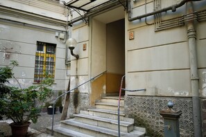 Ein Gebäude mit einer Treppe, einem Blumentopf und einem Strommast.