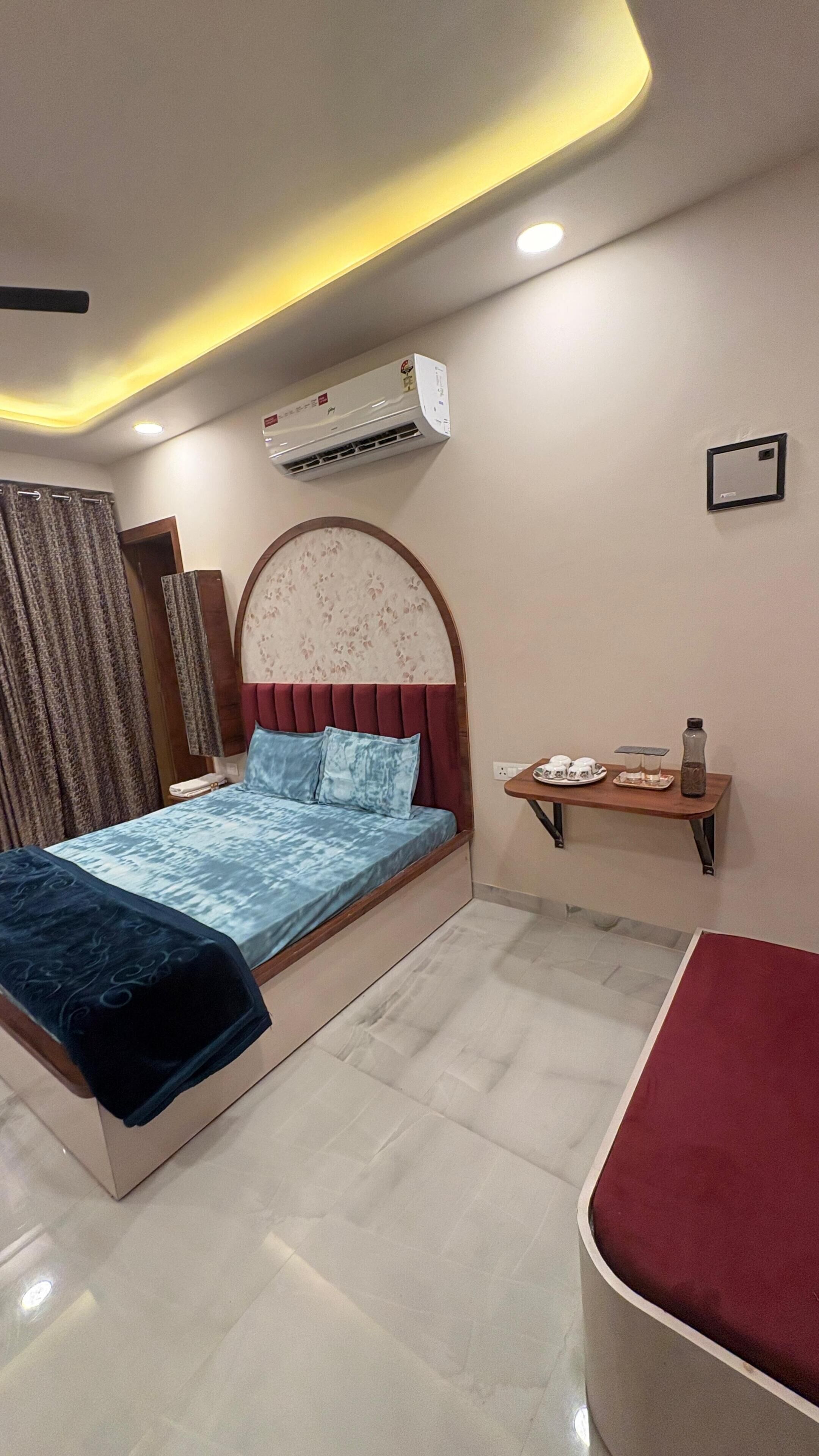 A modern bedroom with a bed, bedside table, and an air conditioning unit.