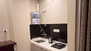 A compact kitchen with a sink, countertop, and a small trash bin.