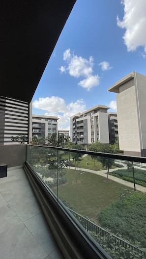 A balcony with a view of modern buildings and a clear sky.
