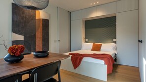 A modern bedroom with a bed, bedside tables, and a wall-mounted light fixture. - San Pietro Terrace by the Sea (Portovenere)