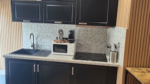 A modern kitchen with dark cabinets, a microwave, a sink, and a wooden countertop. - Superb small air-conditioned 2-bedroom apartment Ideally located (Avignon)