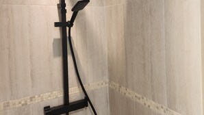 A shower with a handheld showerhead and a fixed overhead showerhead, mounted on a wall with a tiled design. - Superb small air-conditioned 2-bedroom apartment Ideally located (Avignon)