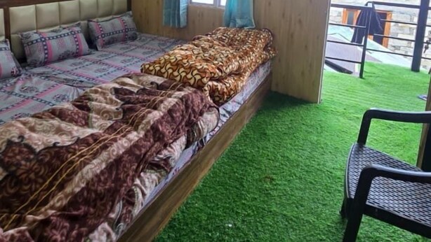 Una habitación con una cama, un ventanal con cortinas y vistas al exterior.