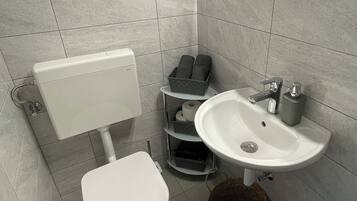 Een haardroger, handdoeken, zeep, toiletpapier