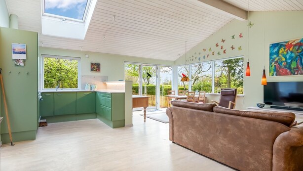 A modern living space with a kitchen, dining area, and a large window overlooking greenery. - "Amina" - 500m from the sea by Interhome (Egå)