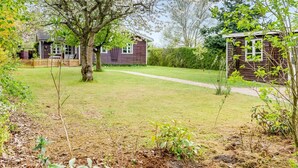 A residential property with a grassy yard, a wooden fence, and two houses. - "Amina" - 500m from the sea by Interhome (Egå)