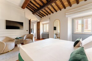Ein Schlafzimmer mit einem Bett, einem Fernseher, einem Spiegel und einem Fenster.