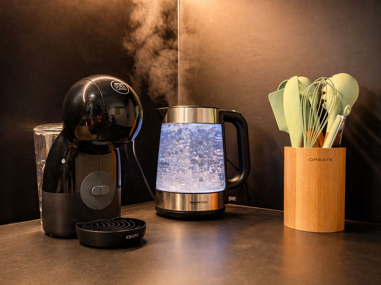 A kitchen with a coffee maker, a kettle, and a wooden utensil holder.