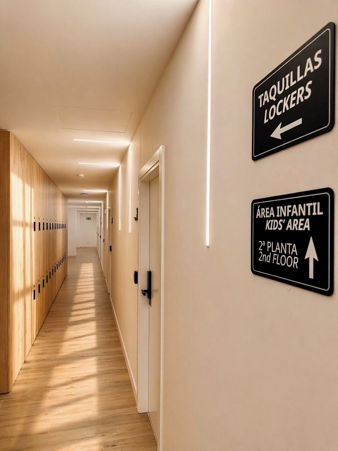 A hotel corridor with lockers, an infant area, and a second-floor sign.