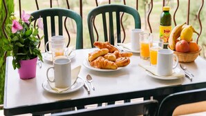 A table set with breakfast items, including croissants, juice, and a fruit basket, on a balcony with a view. - Spacious Provence Retreat for 8 Guests (Paradou)